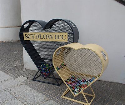 Fotografia przedstawia metalowe serca, pełniące funkcję pojemnika na plastikowe zakrętki.