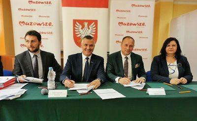 Burmistrz Szydłowca- Artur Ludew, Wicemarszałek Wojeówdztwa Mazowieckiego Rafał Rajkowski oraz skarbnik Gminy Szydłowiec Iwona Czarnota, siedzą przy stole w trakcie podpisania umowy o MIAS.