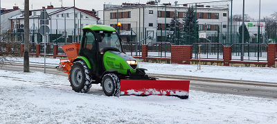 Ciągnik odśnieżający chodnik.
